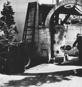 876765 Afbeelding van vermoedelijk 'vader' Huisman die de ketel voor de gaarkeuken op de binnenplaats van het klooster ...